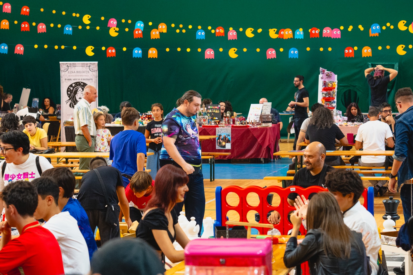 Evento ludico in palestra con giochi e bancarelle.