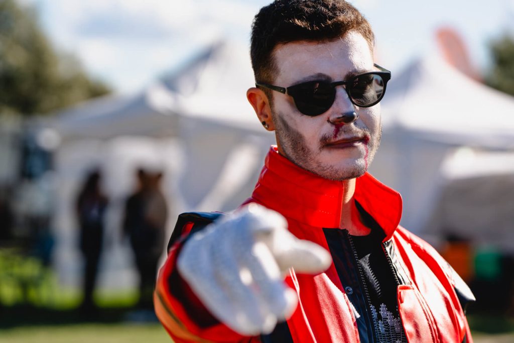 Persona in costume con giacca rossa e occhiali da sole