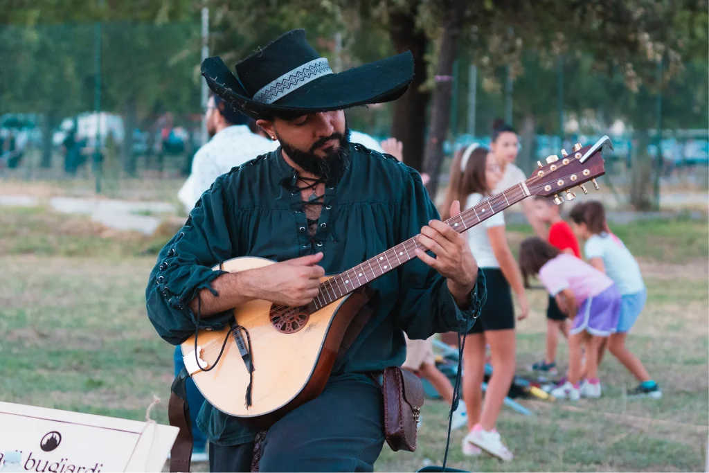 Musicista con cappello suona liuto al parco