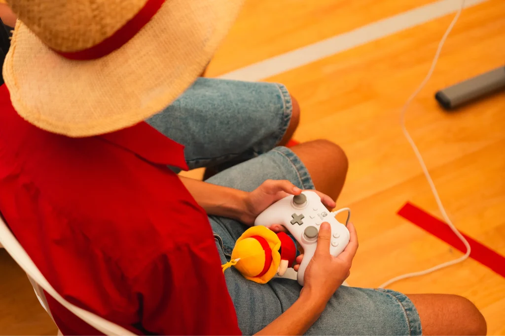 Ragazzo con controller gioca seduto in casa